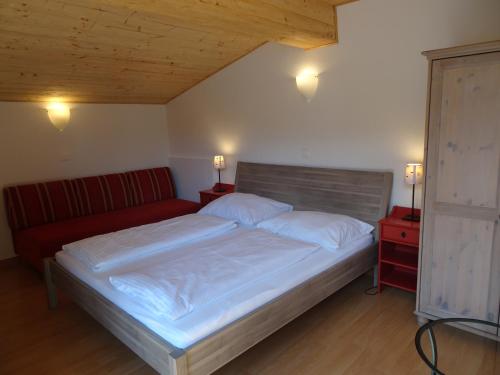 a bedroom with a bed and a red couch at Schlossalm Appartement in Bad Hofgastein