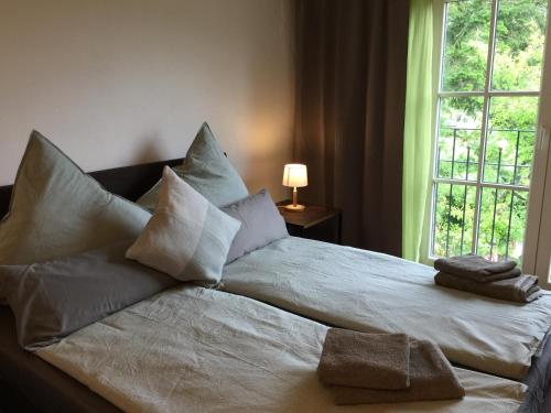 1 cama con 2 toallas y ventana en Zum Schwalbennest, en Wredenhagen
