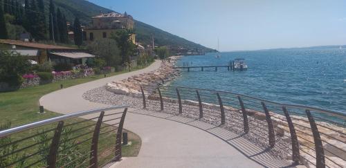 a walkway next to a body of water at l'angolo sul porto in Brenzone sul Garda