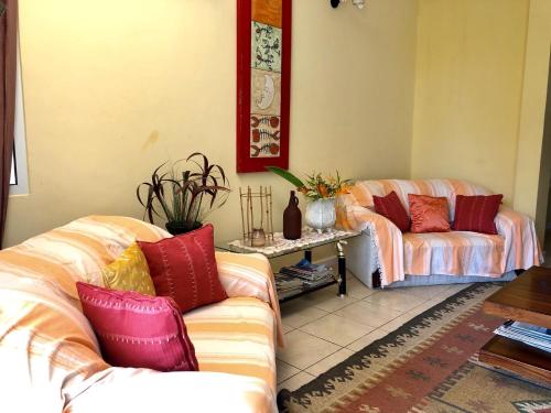 a living room with two couches and a table at Residence Monte-Cristo in Anse Boileau