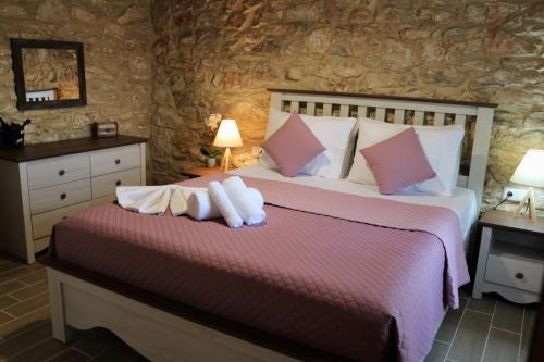 a bedroom with a bed with two towels on it at Vasilis House in Theológos