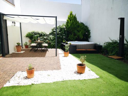 アラセナにあるAracena Suitesの庭にテーブルと鉢植えの植物があるパティオ