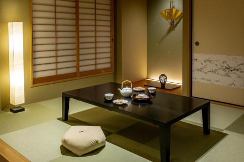 a living room with a black table and a stool at Hauza Kyoto Gojo Karasuma in Kyoto
