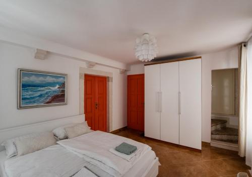 Un dormitorio con una cama blanca y una pintura en la pared en Apartment Teatar en Korčula
