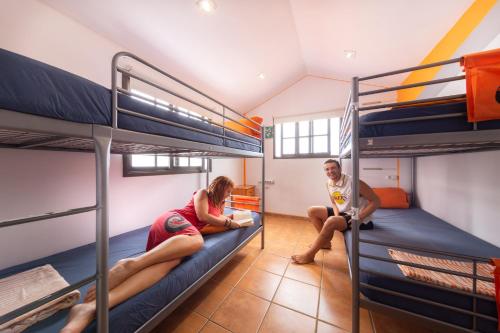 two people sitting on bunk beds in a hostel at La Tortuga Hostel in Adeje