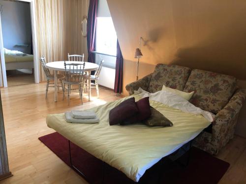 Bett im Wohnzimmer mit Sofa und Tisch in der Unterkunft Staby Gårdshotell in Högsby