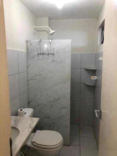 a white bathroom with a toilet and a sink at Apartamento Beira Mar no 2ºAndar - TIBAU DO NORTE - RN in Tibau do Sul