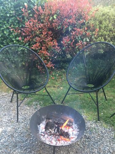 dos sillas alrededor de una hoguera en un patio en Gites Libellule, en Aleu
