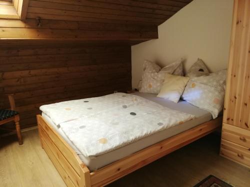 Am Mondseeblick في موندزي: سرير في غرفة ذات اطار خشبي