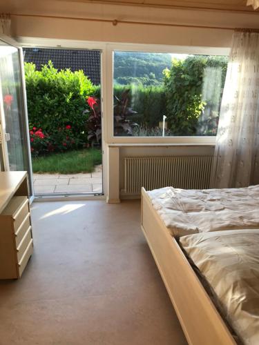 1 dormitorio con cama y ventana grande en Ferienwohnung mit Terrasse bei Nürnberg, en Happurg