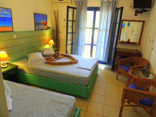 a bedroom with a bed with a wooden headboard at Kalamitsi Studios in Kalamitsi