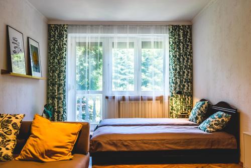 a bedroom with a bed and a window and a couch at Czas na Puszczę in Puszcza Mariańska
