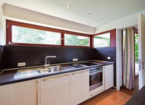 a kitchen with a sink and a stove and windows at Central Hotel-Apart München in Munich