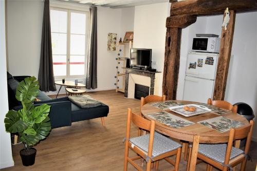 een keuken en een woonkamer met een tafel en stoelen bij Gite Le Nid des Zoo Zio, 5mn Beauval, appartement terrasse centre-ville in Saint-Aignan