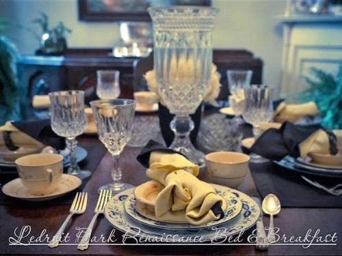 tavolo da pranzo con tavolo, piatti e posate di Ledroit Park Renaissance Bed and Breakfast a Washington