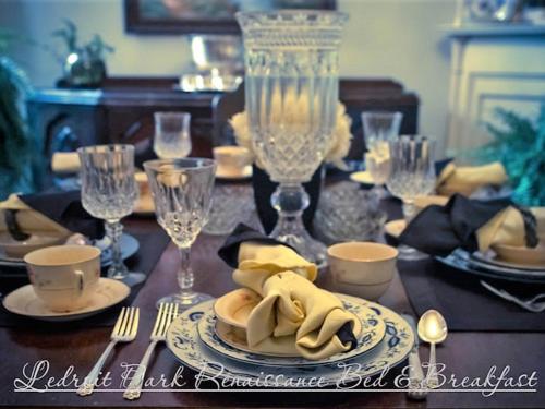 a dining room table with a table set with plates and silverware at Ledroit Park Renaissance B&B in Washington, D.C.