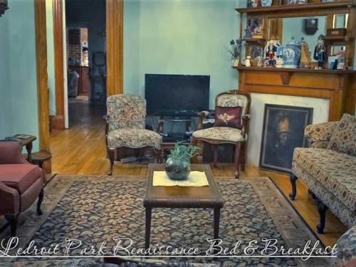 a living room with a fireplace and a tv at Ledroit Park Renaissance Bed and Breakfast in Washington, D.C.