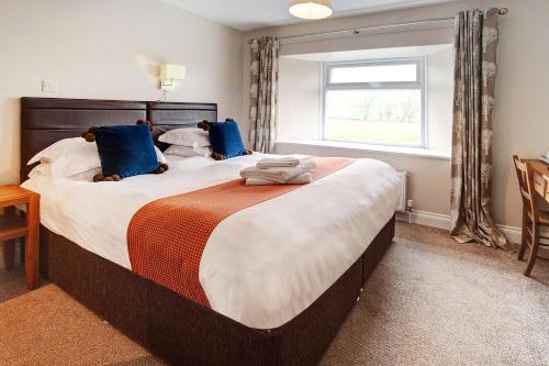 A bed or beds in a room at The Twice Brewed Inn 