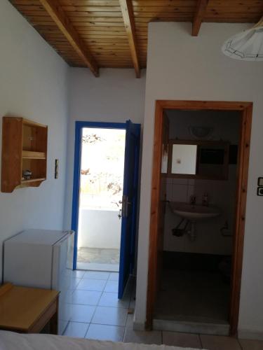 a kitchen with a door leading to a sink at Oasis Hotel Loutro in Loutro