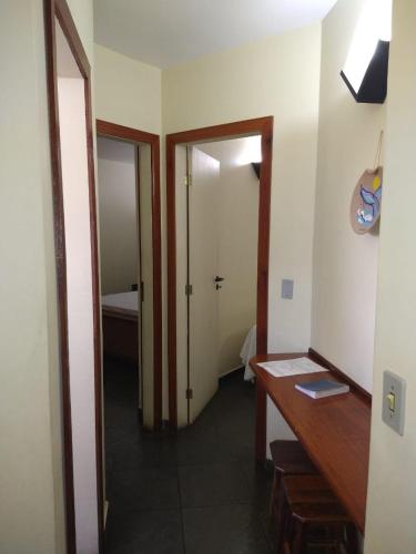 a room with a desk and a door to a bathroom at Pousada Genesis in Arraial do Cabo
