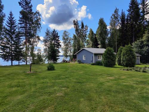 a house on a grassy field with a house at Villa Kesäranta in Jämsä