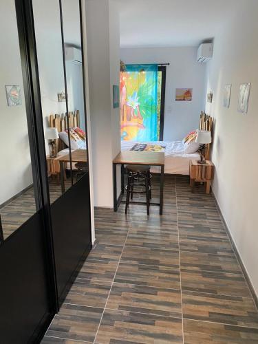 - un couloir avec une table et un lit dans une chambre dans l'établissement ALOHA, à La Grande Motte