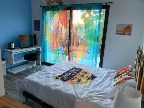 une chambre avec un lit avec un tableau sur le mur dans l'établissement ALOHA, à La Grande Motte