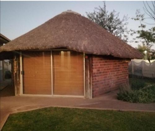 a garage with a thatch roof on top of it at The Lapa Apartment in Gobabis