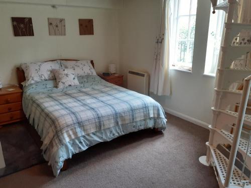 a bedroom with a bed and a window and a shelf at Alum House in Tewkesbury