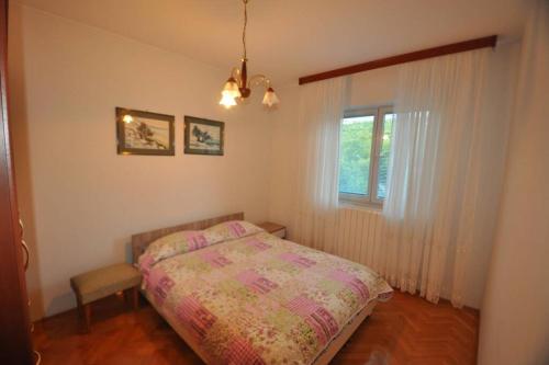 a bedroom with a bed and a window at Lux apartman LEO in Kostrena