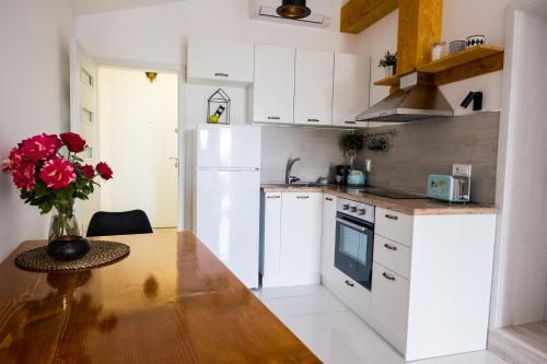 a kitchen with a wooden table and a white refrigerator at Tarno Guest House in Veliko Tŭrnovo