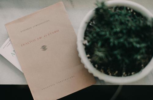 a card next to a pot with a plant at Pension Nikolaos in Nafplio