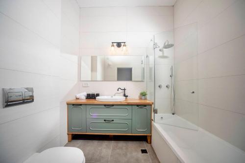 La salle de bains est pourvue d'un lavabo et d'une baignoire. dans l'établissement Stylish Garden Apartment Close to Akhziv Beach by Sea N' Rent, à Nahariya