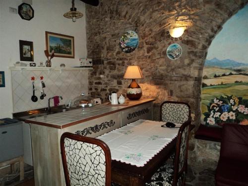 una cucina con bancone, tavolo e sedie di La Bomboniera di Hanac a Pietrelcina