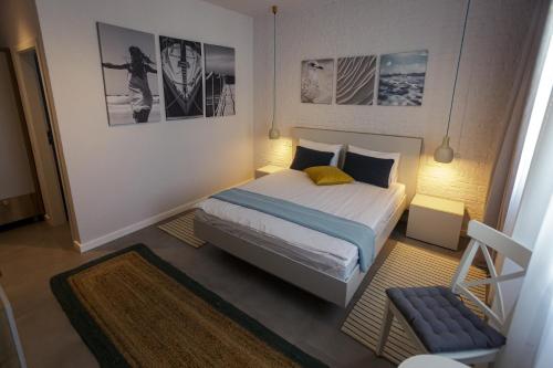 a small bedroom with a bed and a chair at White Vama Veche in Vama Veche