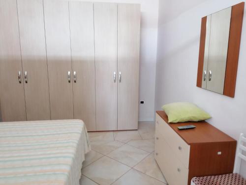 sypialnia z łóżkiem, komodą i lustrem w obiekcie Casa fatone w mieście Cerignola