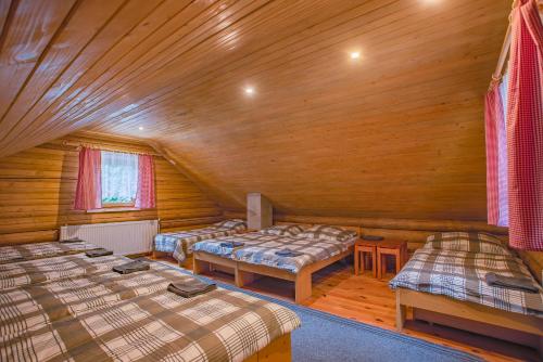 a room with three beds in a log cabin at Chata Hlboké in Bojnice