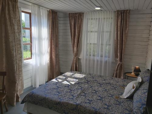 een slaapkamer met een bed en een raam met gordijnen bij Namas su lauko terasa Palangoje in Palanga