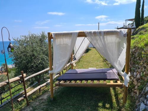 a swinging bed with a canopy and a net at Soqquadro Art&Relax - Spotorno (SV) Sea View in Spotorno
