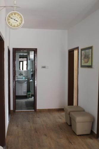 a living room with a clock on the wall and a couch at M apartment in Vršac