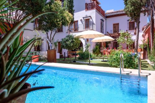 una piscina frente a un edificio con una casa en Alojamiento con Encanto la Luna en el Alba, en Granada