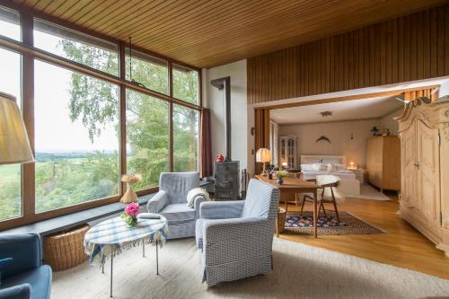 ein Wohnzimmer mit Stühlen und ein Wohnzimmer mit Fenstern in der Unterkunft Ferienhäuschen Sans Pareille bei Bayreuth in Hartmannsreuth