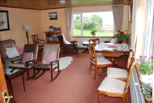 een woonkamer met een eettafel en stoelen bij Dromcloc House in Bantry