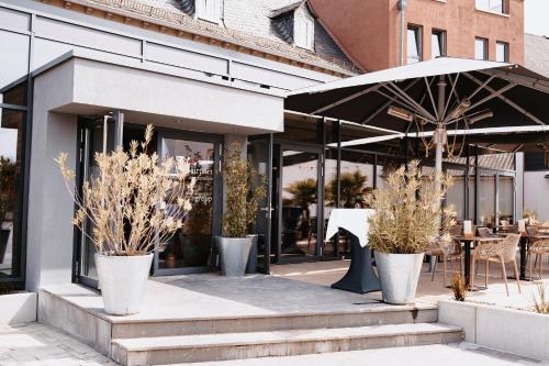 a store front with potted plants and an umbrella at My Place in Lautzenhausen