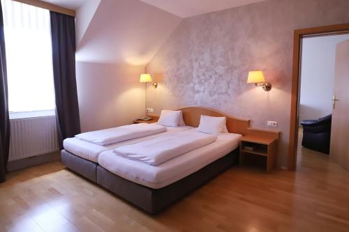 a bedroom with a large bed in a room at Stadthotel GARNI Pinkafeld in Pinkafeld
