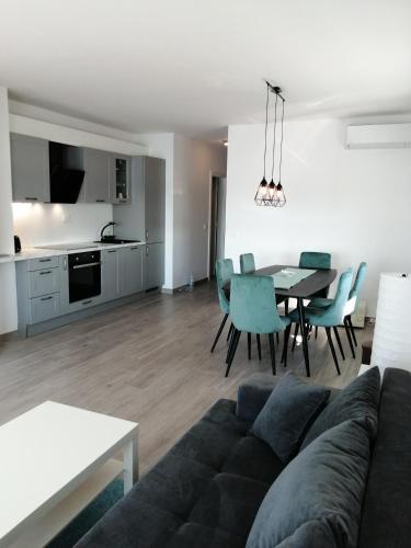 a living room with a couch and a table with chairs at SMARAGD on the beach in Povljana