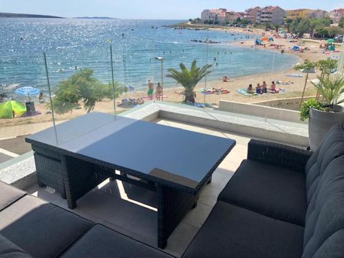a table on a balcony with a view of a beach at SMARAGD on the beach in Povljana