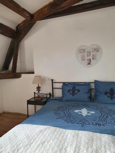 a bedroom with a bed with blue pillows at au Petit Paradis in Sainte-Gauburge-Sainte-Colombe