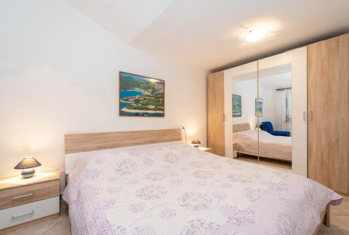 a bedroom with a large bed and a mirror at Apartments Mandica in Rabac