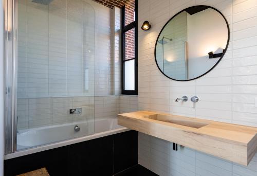 a bathroom with a tub and a sink and a mirror at HARAS DE BARRY in Sainghin-en-Mélantois